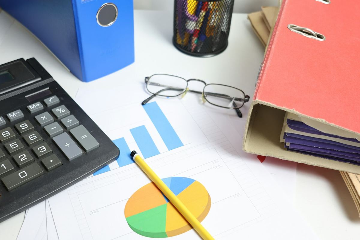 A finance desk with a calculator, charts and files