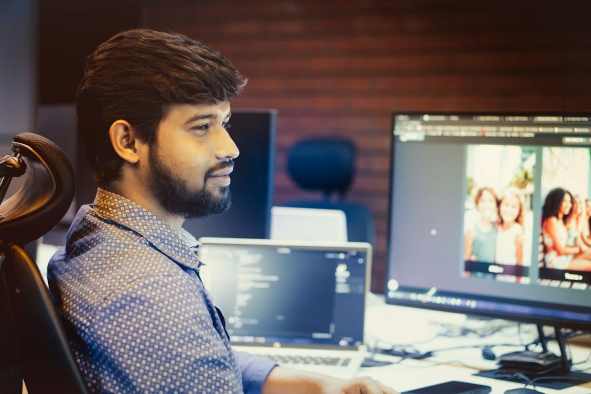 A software engineer at his desk with code on screen